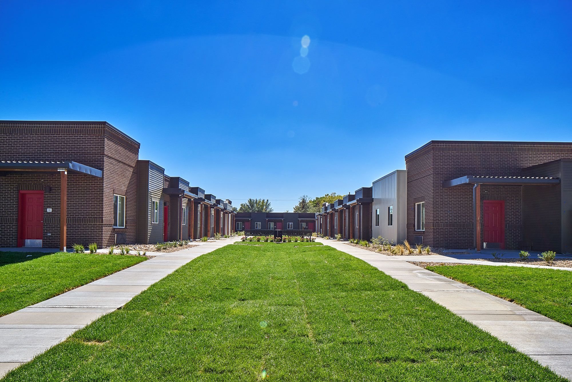 Exterior view of VWC3 showing courtyard surrounded by units made up of green grass and benches